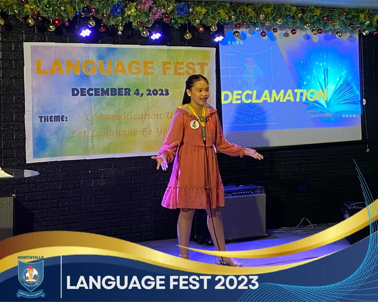 A student speaks on stage in front of a screen reading "Language Fest 2023" during a school program.